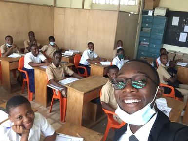Teacher takes a joyful selfie with engaged students in a classroom.